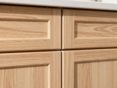 Close-up of newly installed kitchen cabinets, light wood, showing perfect reveals and flush joints under bright natural daylight, crisp focus.