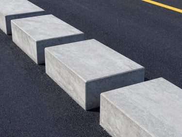 Close-up of concrete curbstones lining a modern asphalt road, sharp edges, clean perspective, architectural lighting