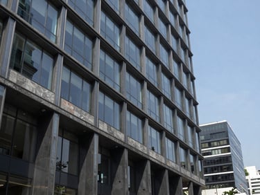 Modern architectural perspective of a corporate office building in Mexico City with steel and glass facade, cool slate tones, crisp daylight, sharp focus, 35mm framing.