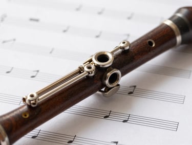 Macro shot of a polished wooden clarinet key mechanism resting on clean white sheet music with elegant hand-written annotations, soft morning light, shallow depth of field