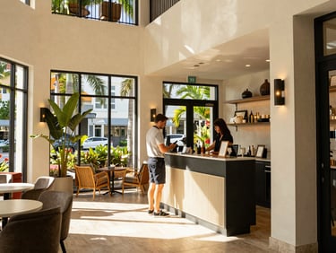 Medium-close editorial shot of a boutique hotel lobby in Sarasota, warm Florida sunlight, a guest checking in, 35mm