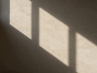 Abstract architectural shadows cast on a textured limestone wall, high-contrast minimalist composition, elegant and quiet