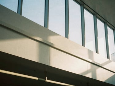 Architectural detail of a quiet, high-end luxury transit hub, clean geometric shadows, soft morning light, editorial 35mm
