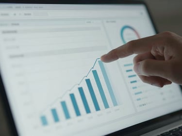 Close-up of a hand analyzing a clean digital dashboard with growth metrics, soft screen glow, cool tones.