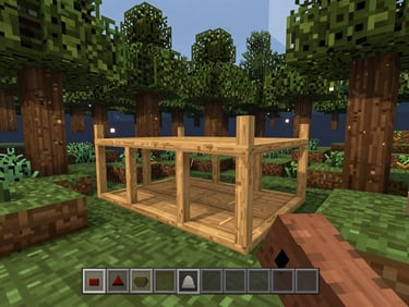 Close-up first-person Minecraft Survival screenshot, dense forest biome at dusk, wooden base under construction in the foreground, full inventory bar visible at the bottom of the frame, warm ambient game lighting unretouched