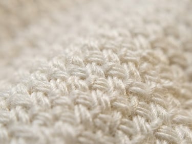 Extreme close-up macro shot of premium white cotton weave, showing high-density threads, soft warm natural morning light, shallow depth of field, minimalist luxury editorial style