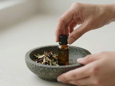 A close-up of hands mixing custom-blended herbal oils in a small stone dish, soft diffused daylight, muted earth tones.