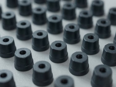 Tight macro shot of organized manufacturing components, desaturated charcoal tones, sharp focus