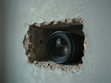 Close-up of a dark cavity inside an old wall, plaster crumbling at the edge, cool ambient light from a nearby window, no people