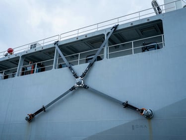 Detail shot of passenger combustion vehicles secured with heavy-duty tie-downs inside a Ro-Ro shipping vessel, cool metallic industrial lighting.
