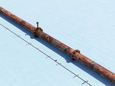 A detailed CAD engineering drawing of a pipeline longitudinal section, showing elevation markers, hydraulic gradient lines, and pipe diameters on a technical blue grid background.