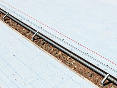 Detailed technical longitudinal profile drawing of a pipeline route, showing elevation lines, ground levels, hydraulic gradient lines, crisp blue grid background, engineering schematic style.