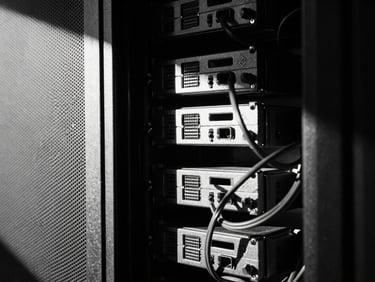 Stark minimalist close-up of server racks and cables, sharp geometric shadows, high-contrast monochrome, 35mm