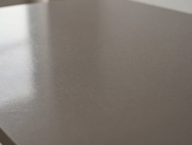 Macro detail of a poured seamless charcoal epoxy surface, liquid-like depth, soft architectural reflection