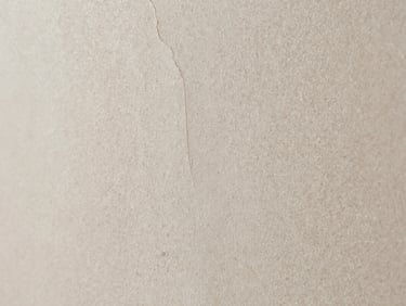 Macro texture of raw textured stone plaster, light beige mineral grains, subtle structural crevices