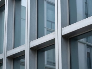 High-contrast architectural photograph of a modern steel and glass partition, sharp metallic frames, cool lighting