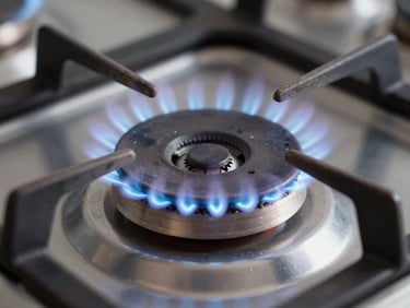 Macro shot of a clean gas range burner ignition spark, crisp blue flame, sharp focus on the burner ring, professional lighting