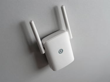 Overhead shot of a ceiling-mount Wi-Fi 6 access point on a neutral light grey surface, antenna array and ethernet port visible, studio strobe overhead lighting, no text or lifestyle staging