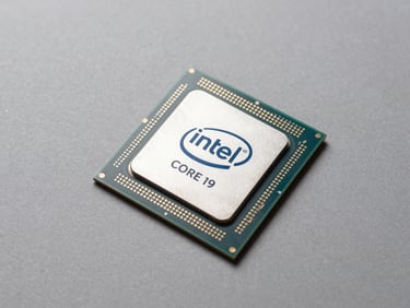 Three-quarter flat-lay overhead shot of an Intel Core i9-13900K processor on a neutral matte grey surface, studio strobe lighting with minimal shadow, pin grid array detail visible