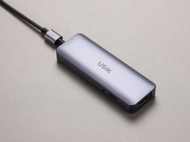 Overhead flat-lay of a USB-C to multi-port hub on a neutral matte surface, studio strobe lighting, port labels and cable detail visible, clean background, minimal shadow