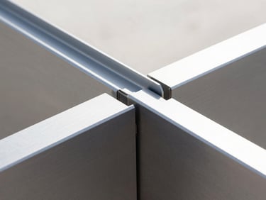 Extreme close-up of a flawless aluminum miter joint, clean anodized charcoal finish, sharp architectural lines, bright daylight