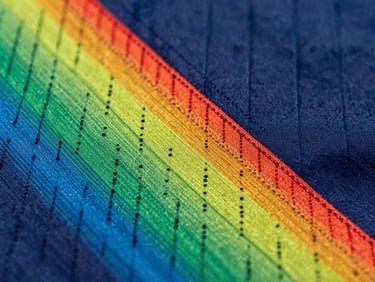 Macro close-up of a custom sublimated soccer jersey showing high-tension flatlock stitching and vibrant zero-bleed moisture-wicking mesh fabric.