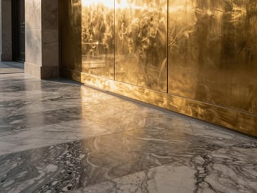 Architectural detail of premium marble flooring meeting a polished brass wall inlay, natural side lighting