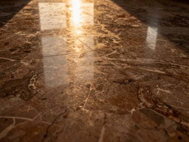 Macro shot of polished Italian marble flooring, golden-hour natural light reflecting off the flawless surface, rich warm tones