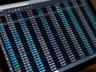 Tight overhead crop of a rank-tracking data table on a dark monitor screen, electric blue position delta indicators, cool LED glow, no faces