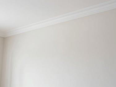 Close-up of a perfectly painted neutral living room wall meeting clean white crown molding, sharp focus, natural daylight