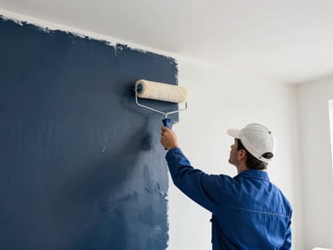 Professional painter using a clean roller to apply primer on a smooth, perfectly prepped drywall surface, bright daylight