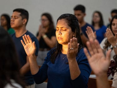 Mãos erguidas em adoração durante um culto, luz dourada, foco nas mãos e rostos expressando fé e devoção
