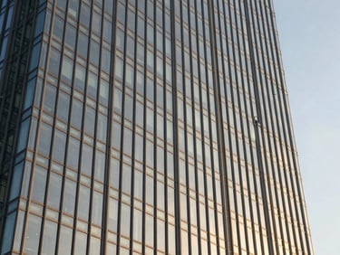 Tight abstract structural detail of a modern glass skyscraper on Golf Course Road, steel frames, warm afternoon light.