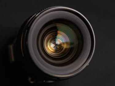 Macro close-up of CCTV camera lens, sharp gold reflections, dark background, high contrast editorial style