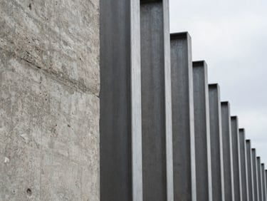 Macro texture of raw structural concrete and steel pillars, sharp architectural lines, overcast daylight.