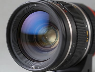 Extreme close-up of a high-end cinema lens reflecting blue neon studio lights, technical markings visible