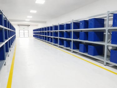 Clean industrial warehouse floor with yellow safety lines, organized racks, bright high-bay lighting
