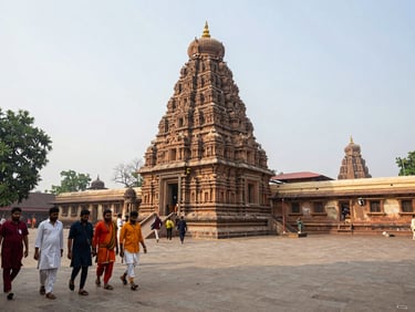 Wide shot of Bodh Gaya's Mahabodhi Temple complex in Bihar, a pilgrim group in the left foreground walking toward the temple, overcast natural daylight, documentary framing