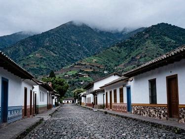 Traditional street in Machachi with cobblestones and misty mountains in the background, cool mountain light, 35mm
