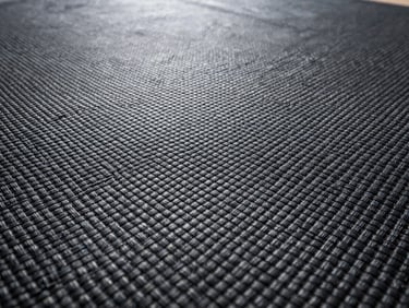 Extreme close-up texture of high-performance woven geotextile fabric, showing the precise interlocking polymer fibers, clean studio lighting.