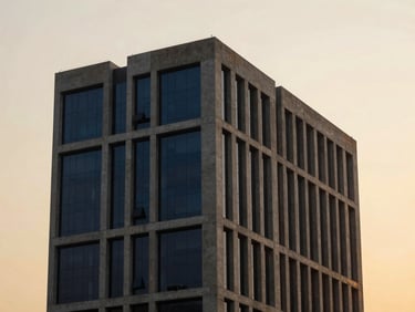 Modern architectural details of a Hyderabad business hub, clean geometric concrete lines against a warm golden-hour sky, 35mm lens