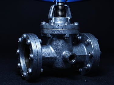 Industrial gate valve, heavy-duty, with sharp metallic highlights and deep shadows, low-key dramatic studio lighting, cool blue undertones, 35mm.