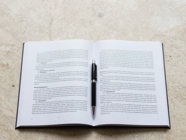 Overhead flatlay of open contract pages on a pale stone desk, a single pen resting across the text, north-facing diffused light, no hands, precise framing with generous space at top
