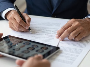 Close-up of hands reviewing documents and digital profiles on a tablet, focused and professional, natural daylight, crisp details, professional corporate realism