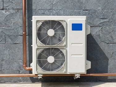Symmetrical front shot of a modern clean heat pump installation against a slate grey wall, precise copper piping, bright natural light, technical photography
