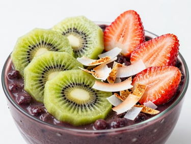 Close-up of a thick purple acai bowl topped with geometric slices of fresh kiwi, strawberries, and toasted coconut flakes in bright studio lighting.