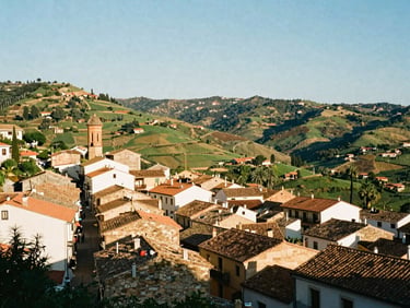 A scenic view of the green hills and traditional rooftops of Cervelló under a clear morning sky, 35mm editorial photography