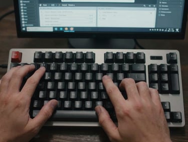 Tight overhead shot of hands on a mechanical keyboard, right index finger mid-click on the Enter key, a campaign-builder interface visible on screen in the background with targeting fields filled in, cool ambient office lighting with faint screen glow, no visible face—only hands and keyboard surface