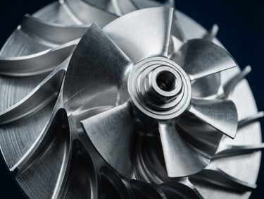 Macro shot of a precision-machined aluminum impeller, clean high-contrast studio lighting, metallic silver and sharp blue tones, 35mm