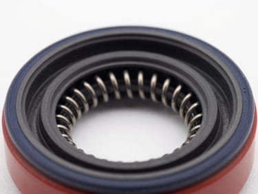 Close-up of a heavy-duty rotary shaft oil seal, black rubber and steel spring details, crisp technical lighting.
